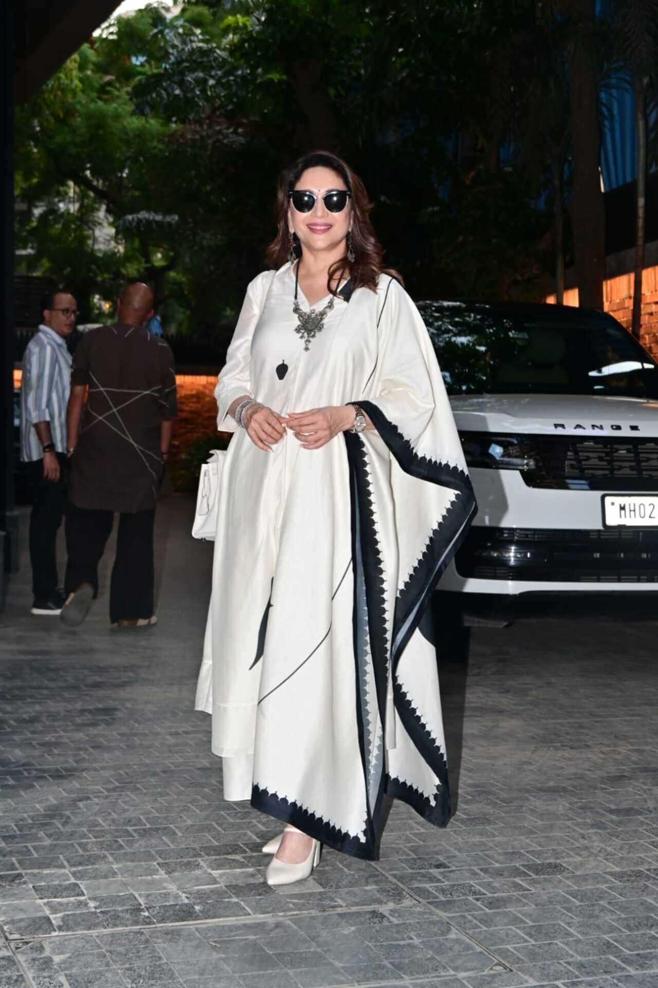 Madhuri Dixit made a graceful appearance in a stunning ivory ethnic outfit featuring elegant black border detailing. She accessorised her look with statement jewellery.